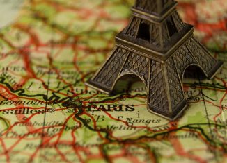 Carte de la France sur laquelle se trouve une Tour Eiffel miniature en métal